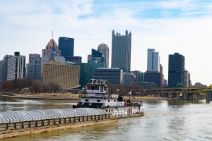 Commercial photo of Tug boat and barge powering down the Ohio Rive in Pittsburgh, PA